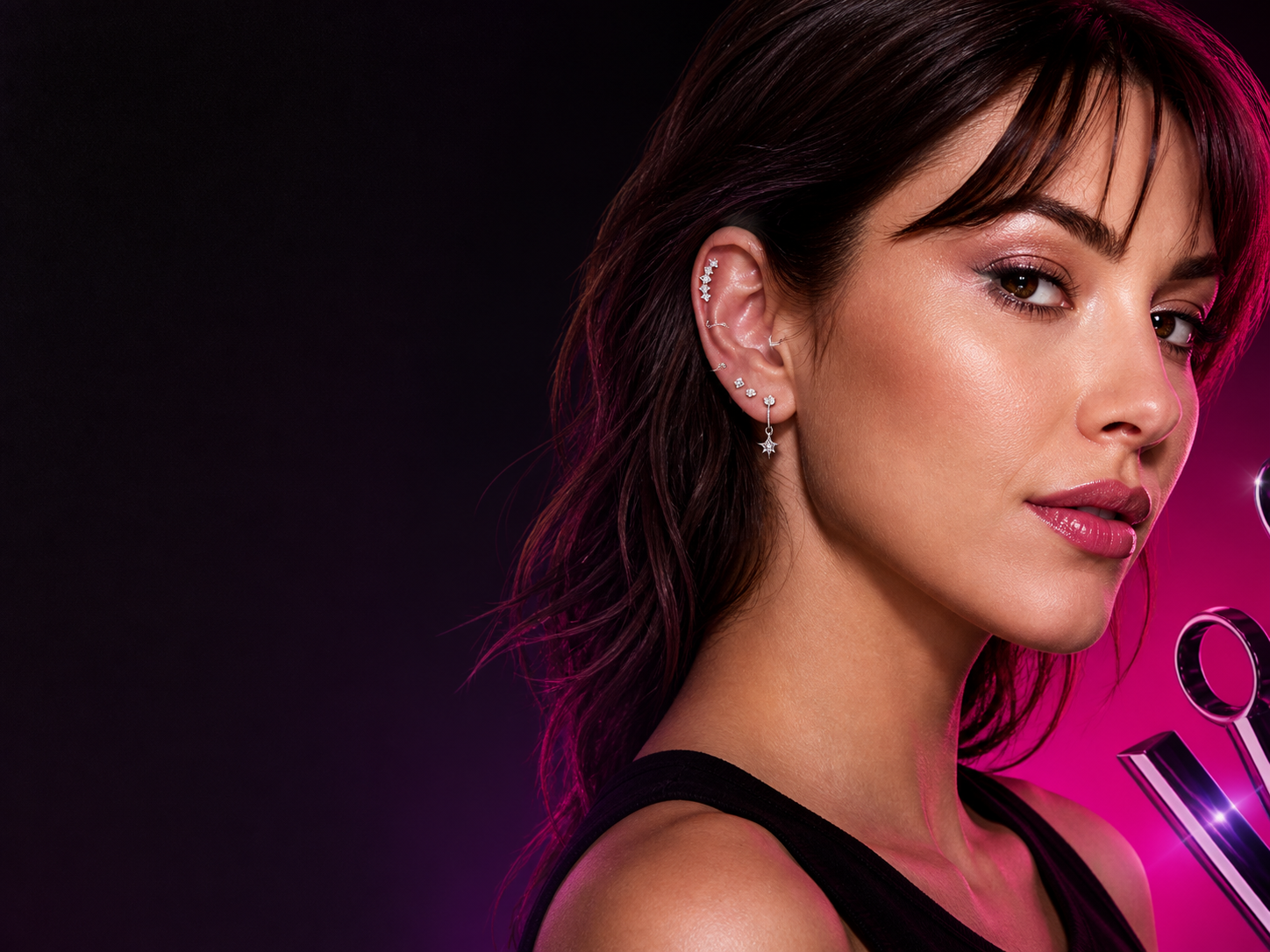 Ear-stacked model against a charcoal and hot-pink backdrop for the Body Jewelry edit.
